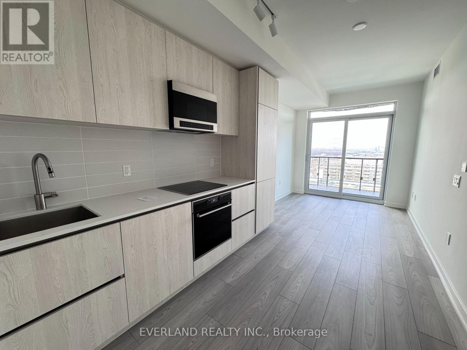 A kitchen with wooden cabinets and a microwave above the stove.