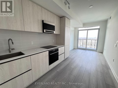 A kitchen with wooden cabinets and a microwave above the stove.