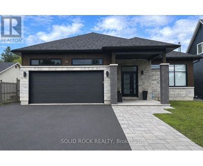 A modern house with a black garage door is for sale.
