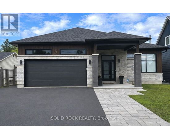 A modern house with a black garage door is for sale.