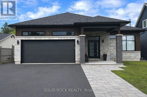 A modern house with a black garage door is for sale.