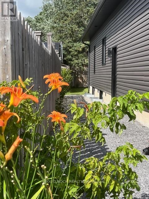 A house with a fence and flowers in front.
