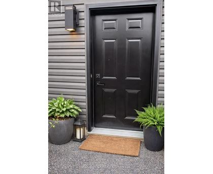 A black door with a mat in front of it.