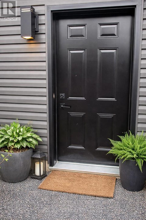 A black door with a mat in front of it.