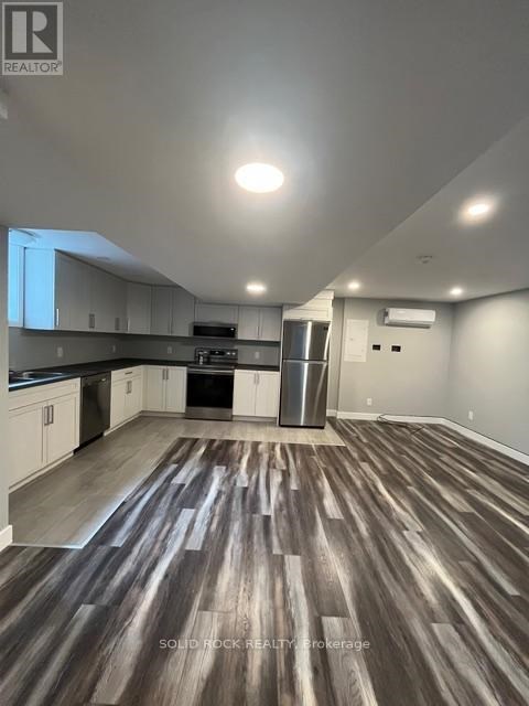 A kitchen with white cabinets and a wooden floor.