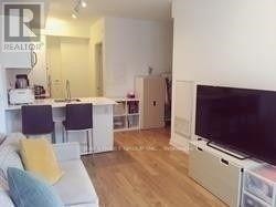 A living room with a white couch and a television.