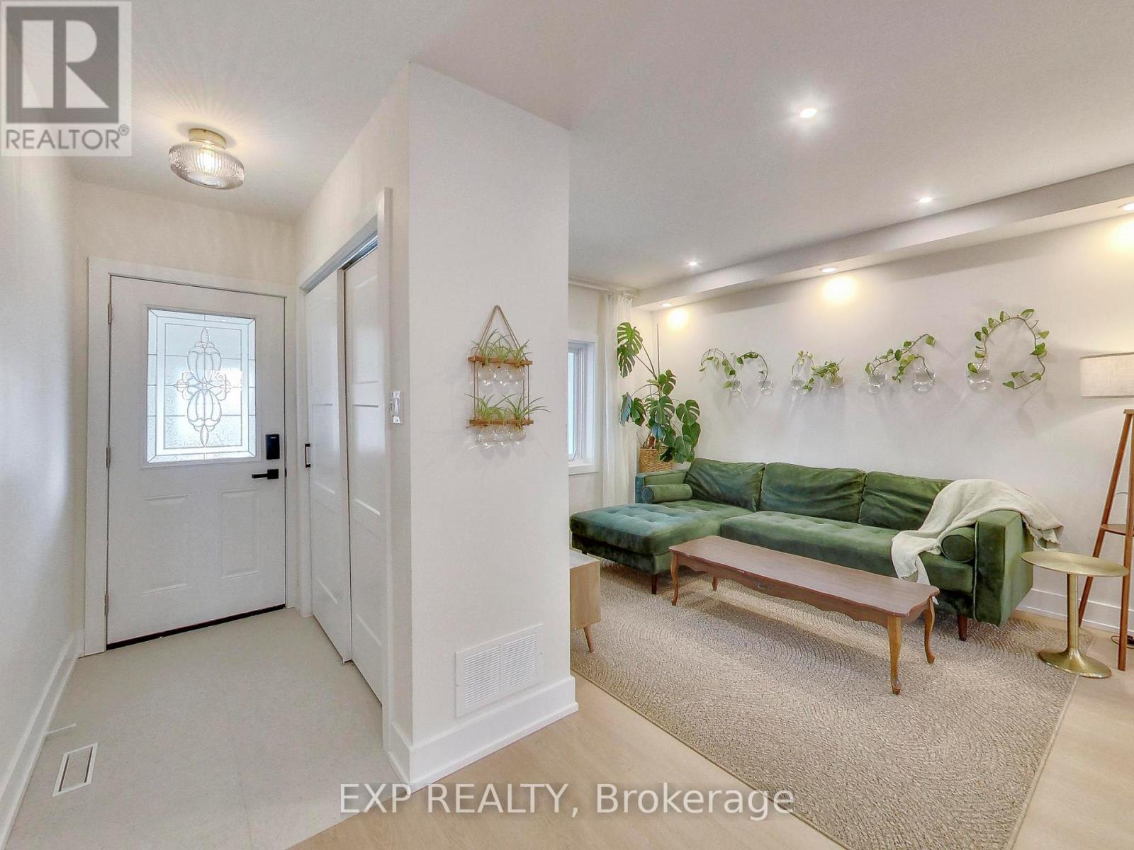 A living room with a green couch and a white door.