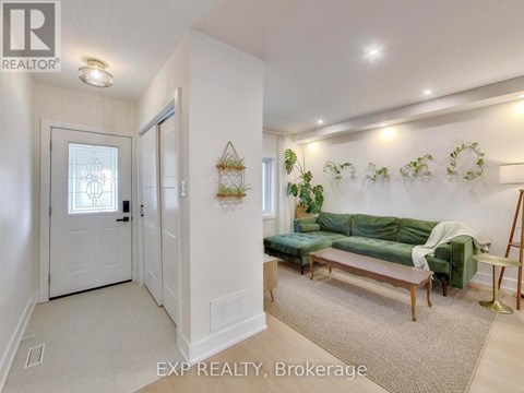 A living room with a green couch and a white door.