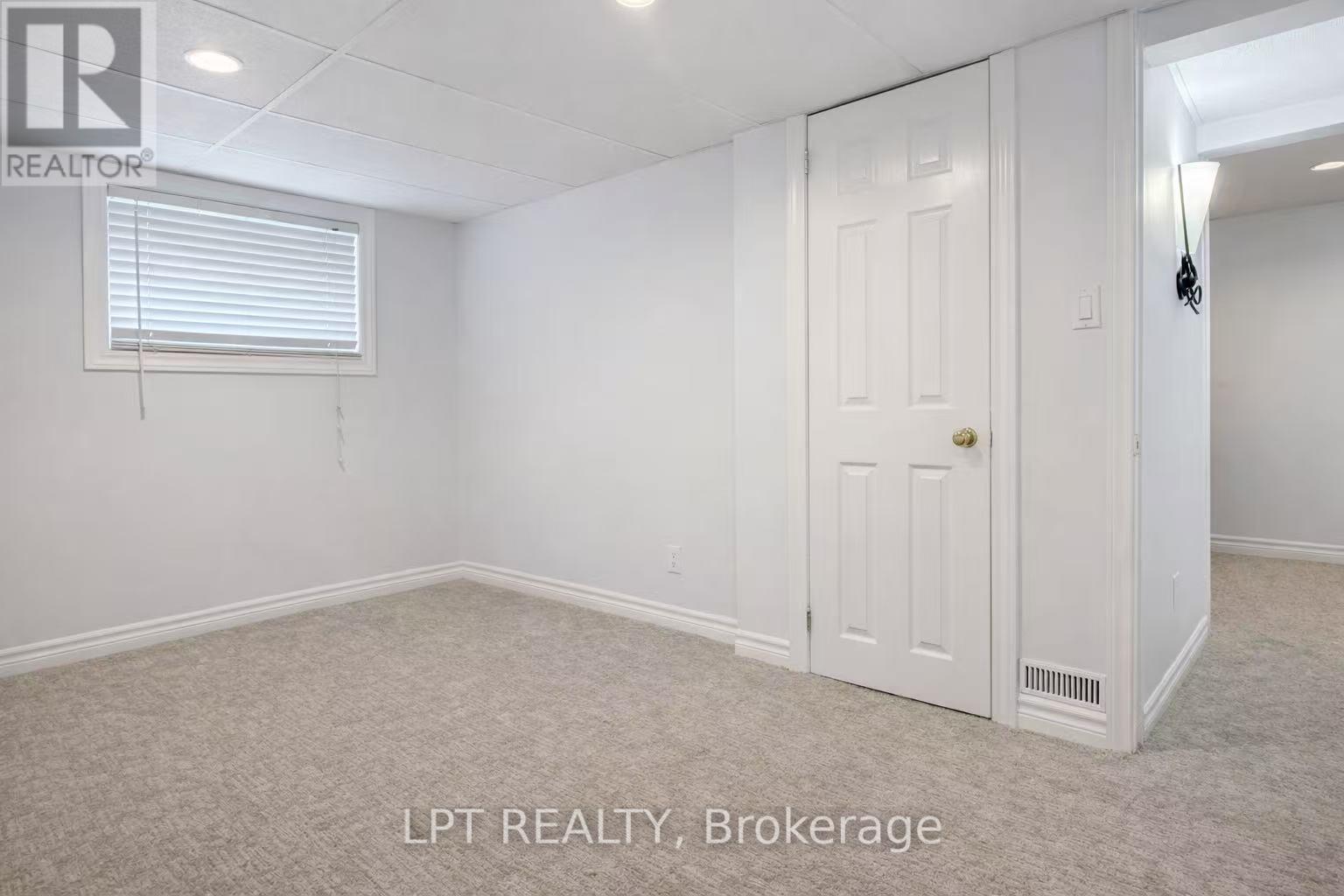 A white bedroom with a door and a window.
