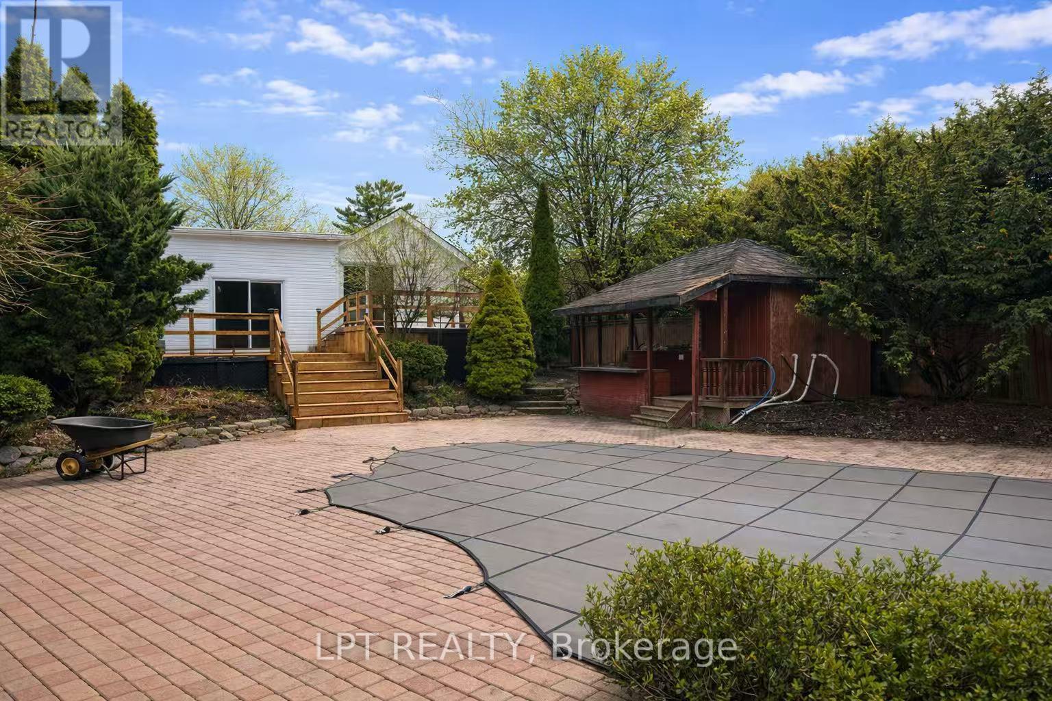 A backyard with a pool and a gazebo.