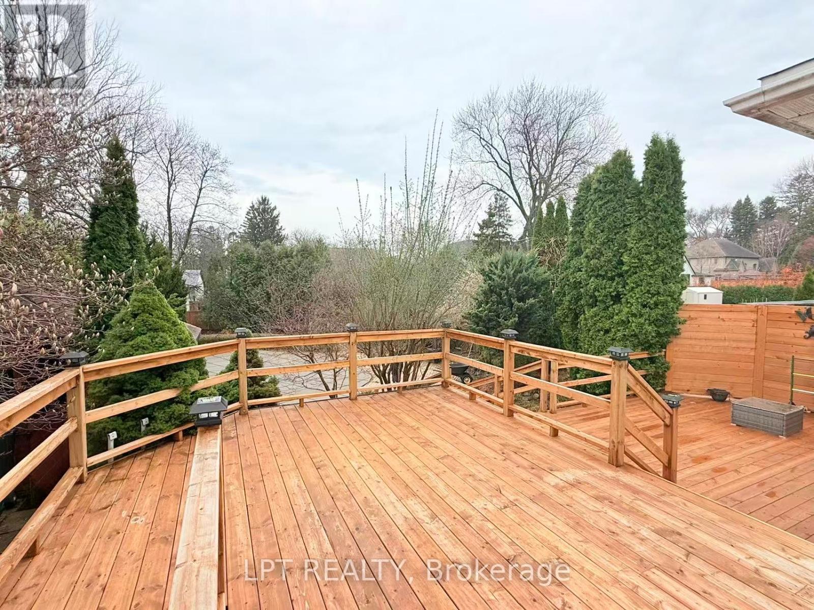 A wooden deck with a railing and a bench.