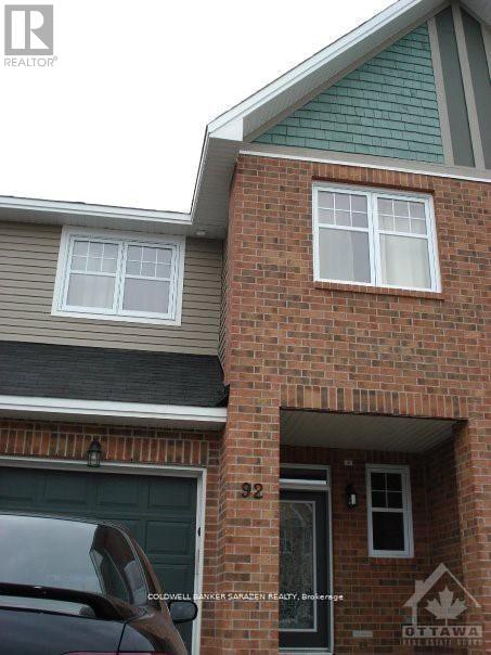 A house with a garage and a car parked in front.