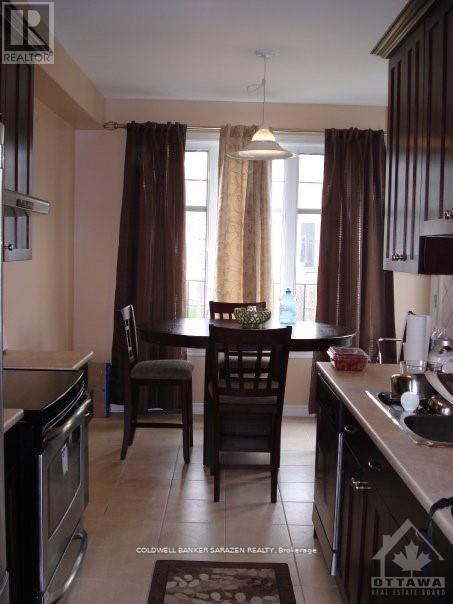 A kitchen with brown curtains and a table set for two.