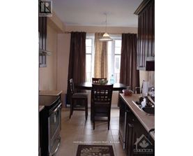 A kitchen with brown curtains and a table set for two.