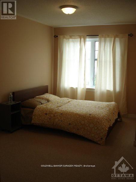 A bedroom with a bed, nightstand, and window with curtains.
