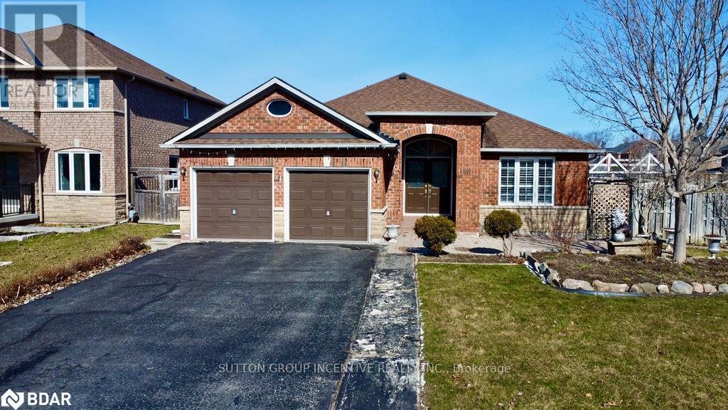 A house with a brick facade and a large driveway in front.