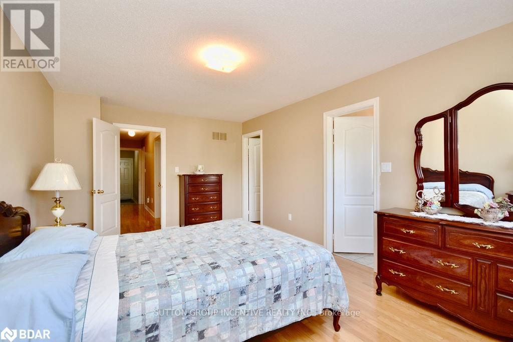 A bedroom with a bed, dresser, and mirror.