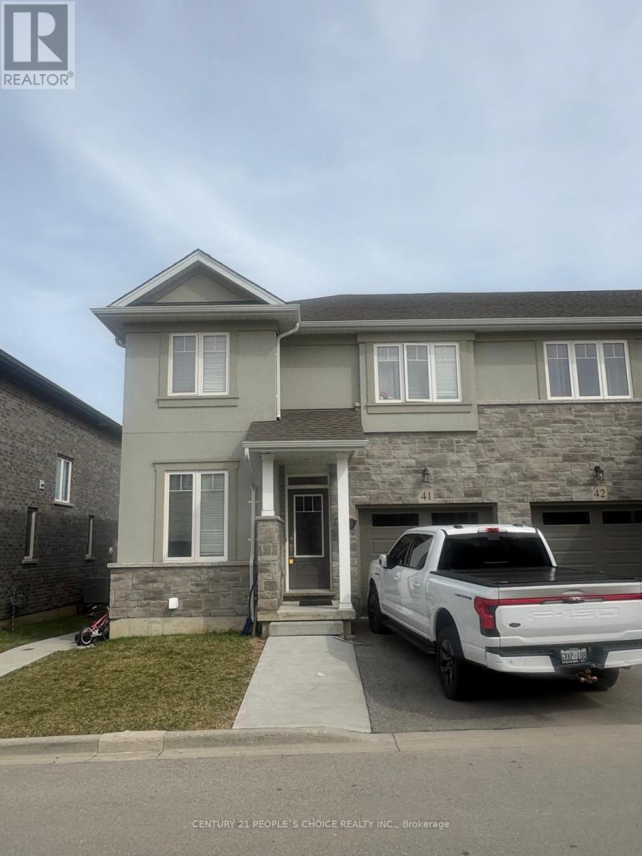 A white truck is parked in front of a grey house.