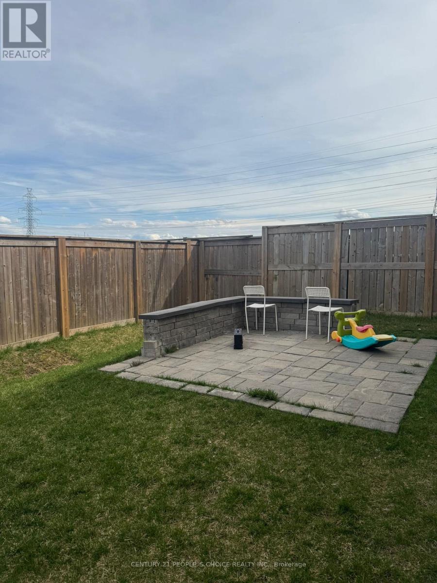 A backyard with a patio and a fence.