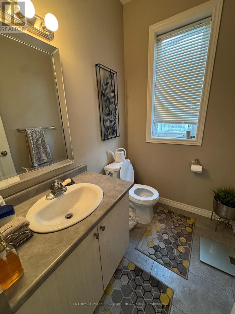 A bathroom with a toilet, sink, and mirror.