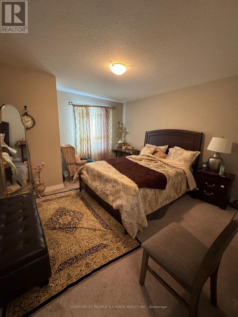 A bedroom with a bed, chair, and rug.