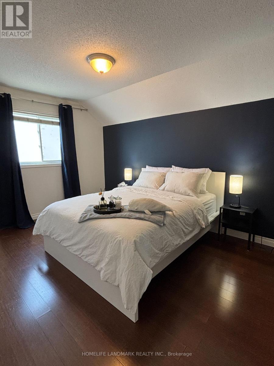 A bedroom with a bed, nightstand, and window.