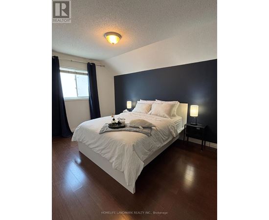 A bedroom with a bed, nightstand, and window.