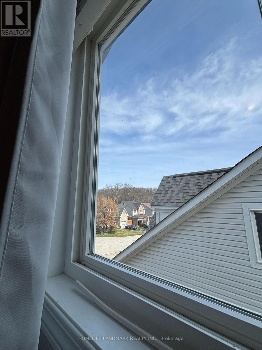 A window with a view of a house and trees.