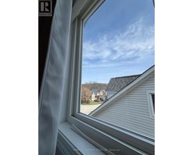 A window with a view of a house and trees.