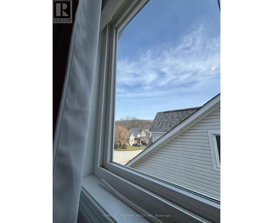 A window with a view of a house and trees.