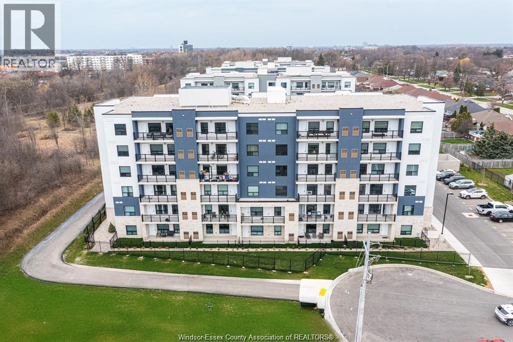 A large apartment building with a parking lot in front.