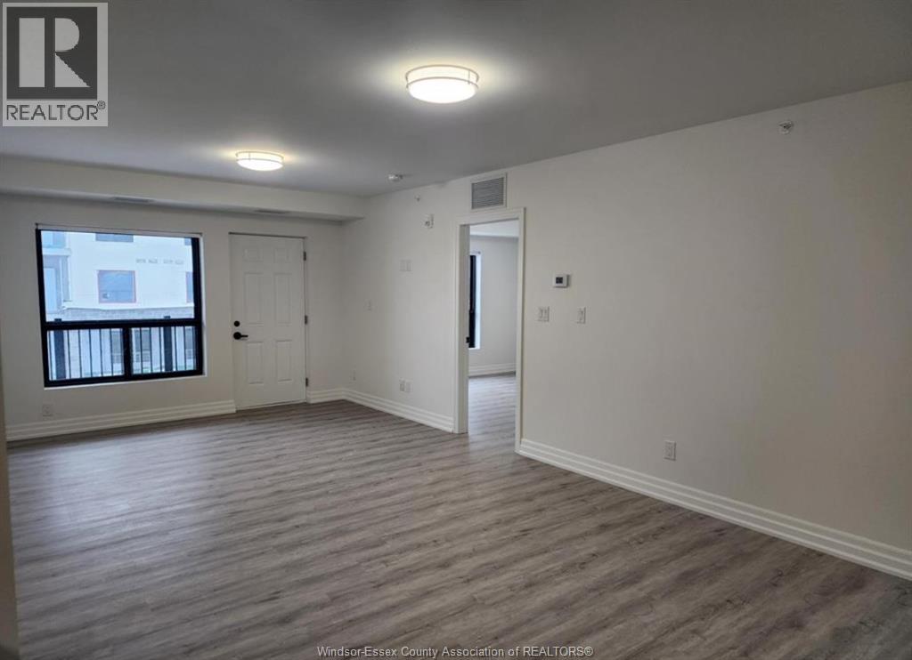 A realtor logo is on the wall in a room with a window and a door.