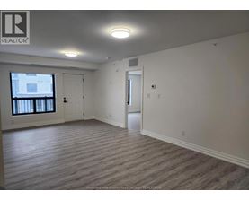 A realtor logo is on the wall in a room with a window and a door.