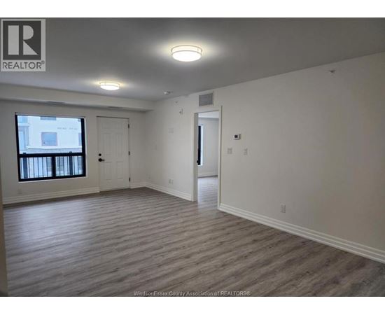 A realtor logo is on the wall in a room with a window and a door.