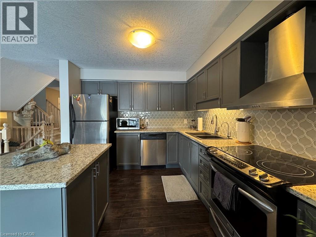 A kitchen with a refrigerator, stove, and dishwasher.