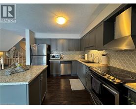 A kitchen with a refrigerator, stove, and dishwasher.