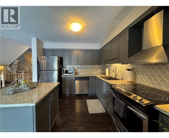A kitchen with a refrigerator, stove, and dishwasher.