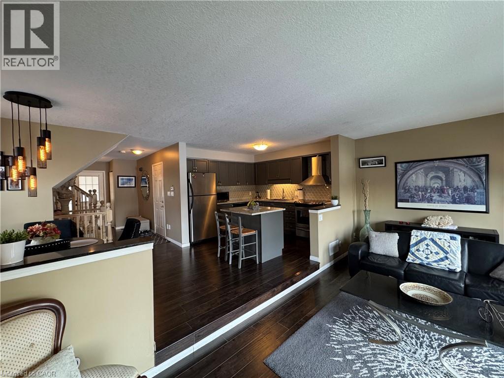 A well-lit open plan living and kitchen area with a dining table and chairs.
