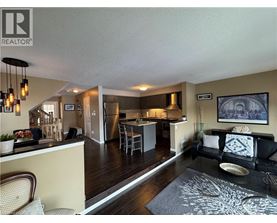 A well-lit open plan living and kitchen area with a dining table and chairs.