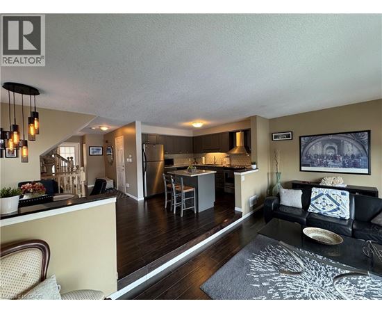 A well-lit open plan living and kitchen area with a dining table and chairs.