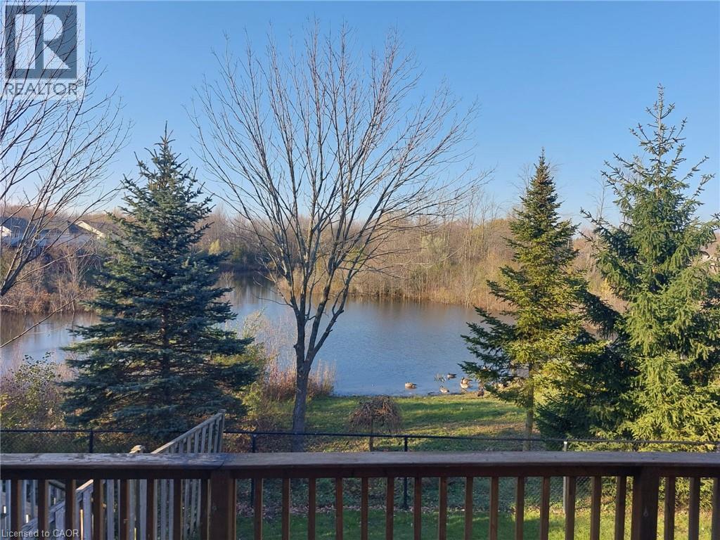 A view from a deck overlooking a lake with trees in the foreground.
