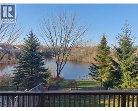 A view from a deck overlooking a lake with trees in the foreground.