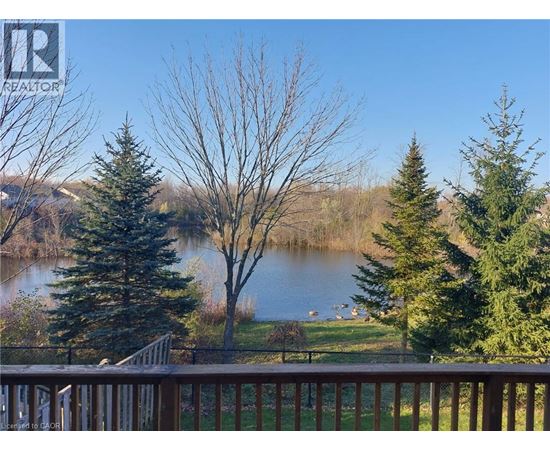 A view from a deck overlooking a lake with trees in the foreground.