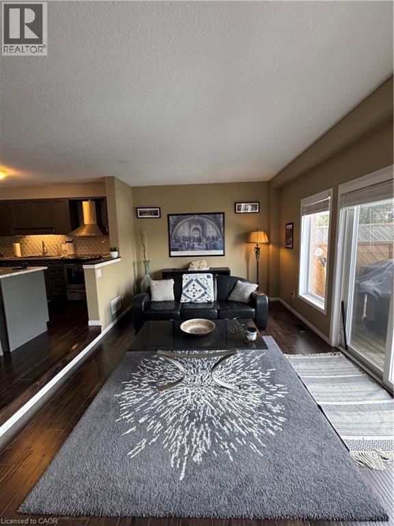 A living room with a grey rug and a black and white couch.