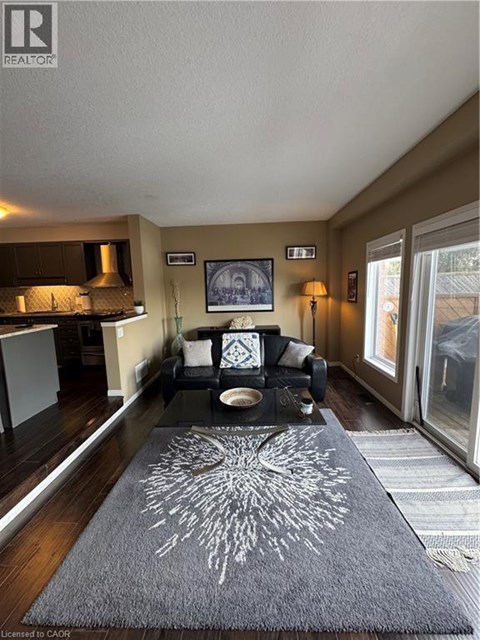 A living room with a grey rug and a black and white couch.