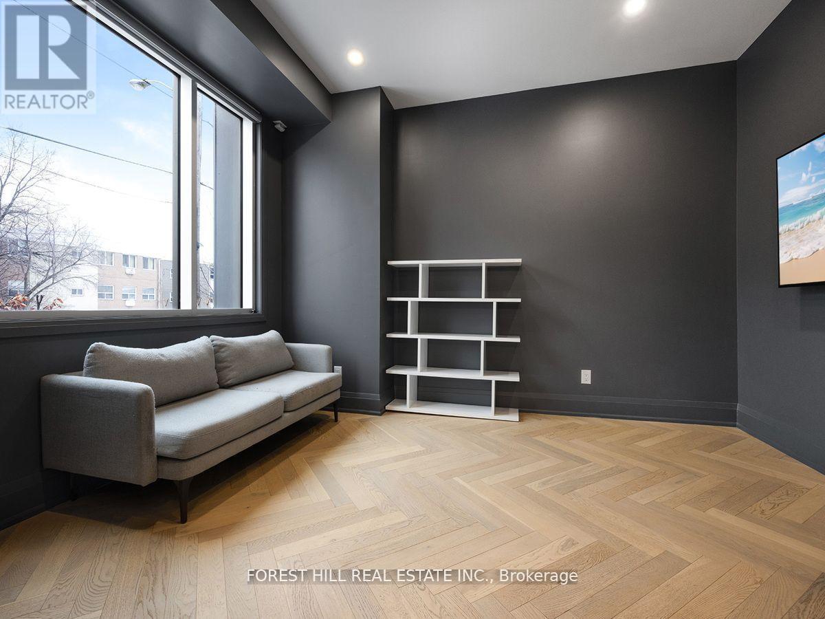 A living room with a grey couch and a wooden floor.