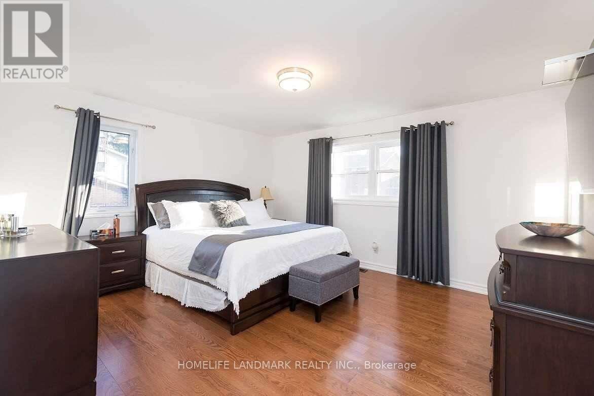 A bedroom with a large bed and wooden floors.