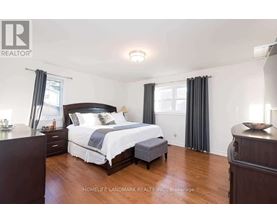 A bedroom with a large bed and wooden floors.