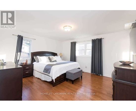 A bedroom with a large bed and wooden floors.