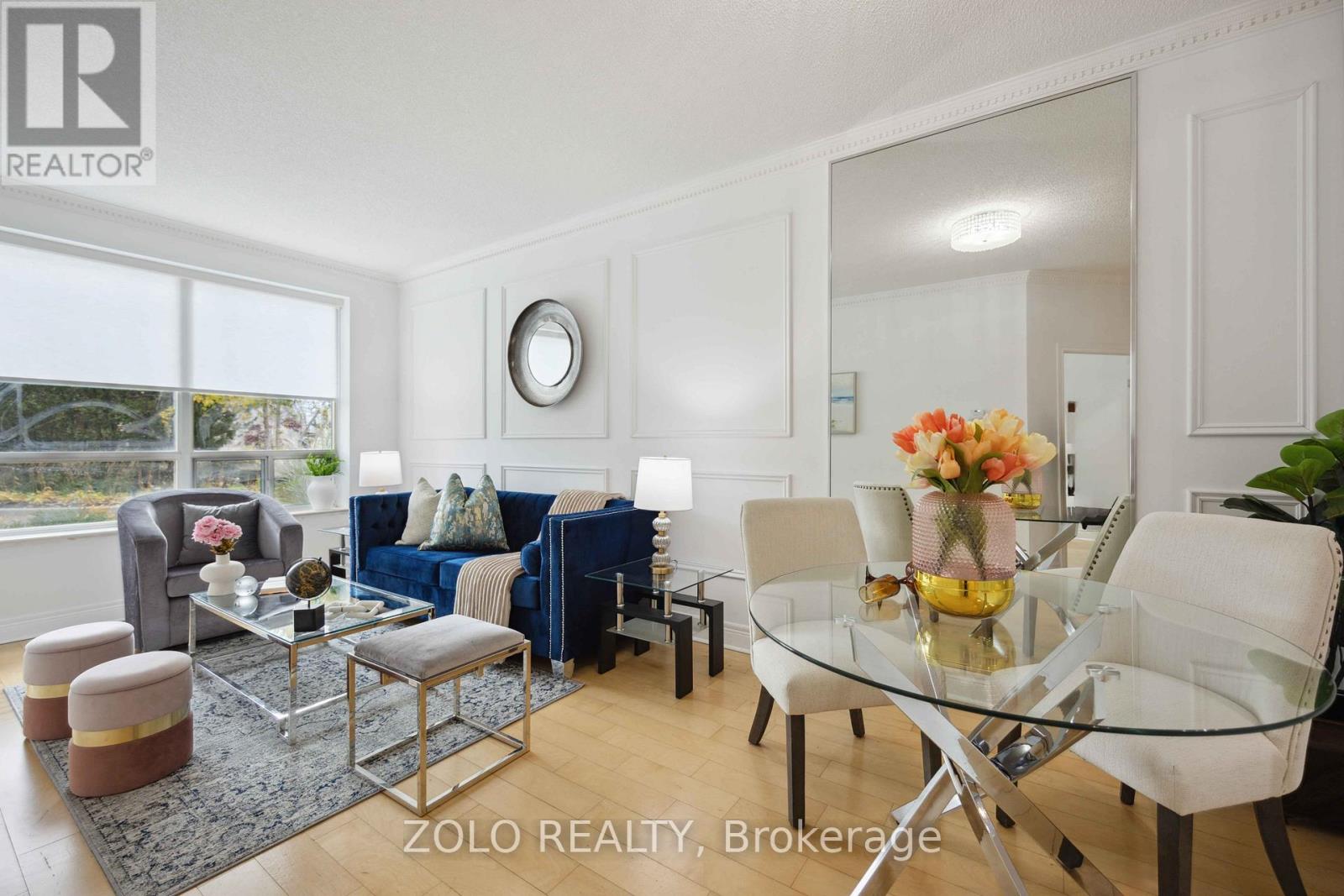 A living room with a glass table and white chairs.